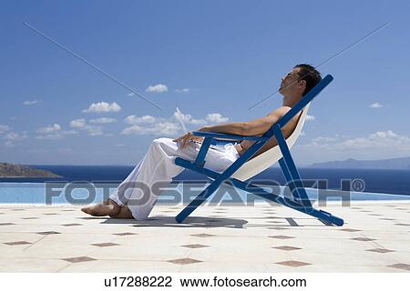 Stock Image - A man relaxing in a deck chair. Fotosearch
