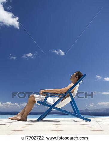 A man relaxing in a deck chair View Large Photo Image Stock Image - A man relaxing in a deck chair. Fotosearch