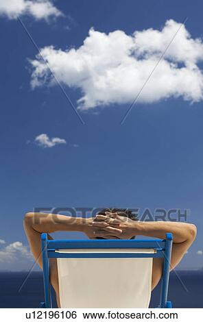 A man relaxing in a deck chair View Large Photo Image Stock Photograph - A man relaxing in a deck chair. Fotosearch