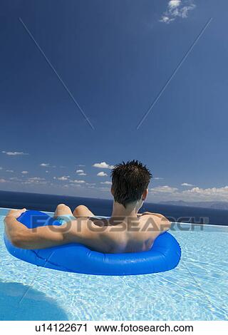 Stock Image - A man relaxing in a pool. Fotosearch