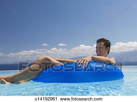 Stock Image - A man relaxing in a pool. Fotosearch