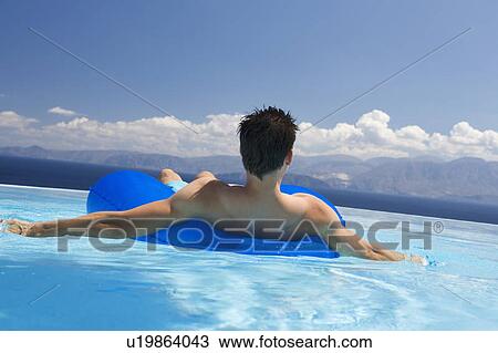Stock Image - A man relaxing in a pool. Fotosearch