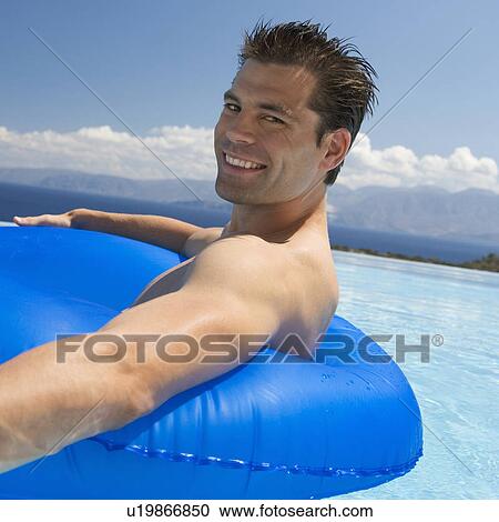 Stock Image - A man relaxing in a pool. Fotosearch