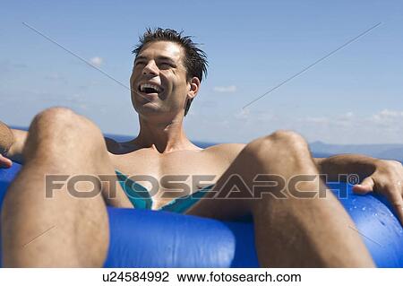 Stock Image - A man relaxing in a pool. Fotosearch