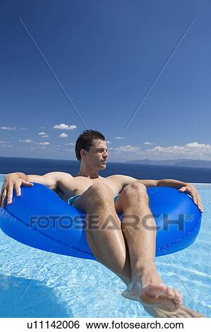 A man relaxing in a pool View Large Photo Image Stock Photograph - A man relaxing in a pool. Fotosearch