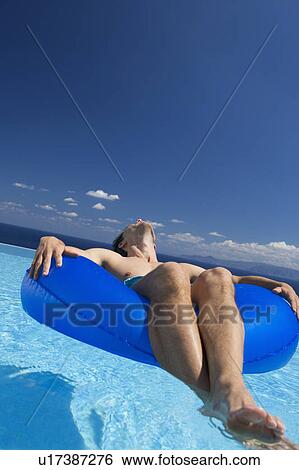 Stock Photograph - A man relaxing in a pool. Fotosearch
