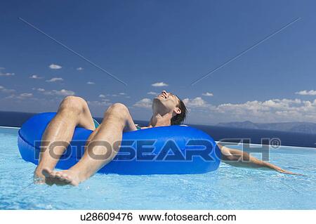 A man relaxing in a pool View Large Photo Image Stock Photograph - A man relaxing in a pool. Fotosearch