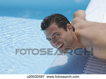 A man sunbathing by a pool View Large Photo Image Stock Photo - A man sunbathing by a pool. Fotosearch
