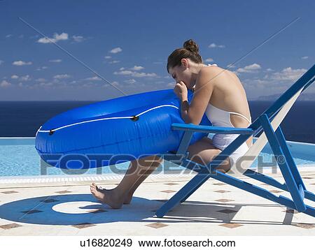 A woman blowing up an inflatable ring to use in a pool View Large Photo Image Stock Photo - A woman blowing up an inflatable ring to use in a pool. Fotosearch