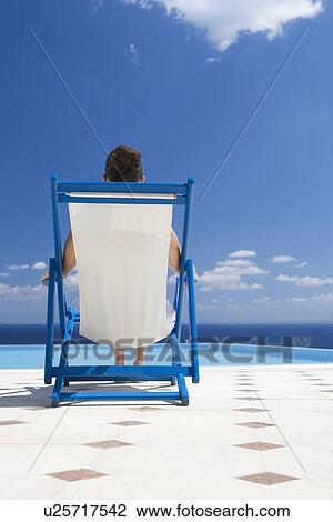 Stock Image - A woman relaxing in a deck chair. Fotosearch