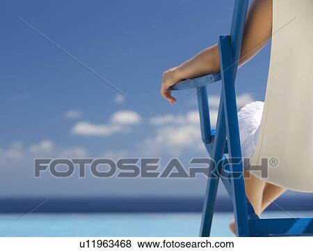 A woman relaxing in a deck chair View Large Photo Image Stock Photo - A woman relaxing in a deck chair. Fotosearch
