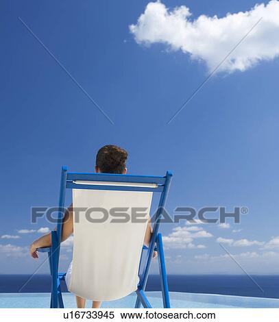 Stock Photography - A woman relaxing in a deck chair. Fotosearch