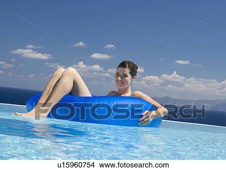 Picture - A woman relaxing in a pool. Fotosearch