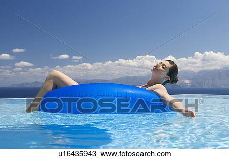 Stock Image - A woman relaxing in a pool. Fotosearch