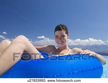 Stock Image - A woman relaxing in a pool. Fotosearch