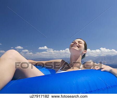 Stock Image - A woman relaxing in a pool. Fotosearch