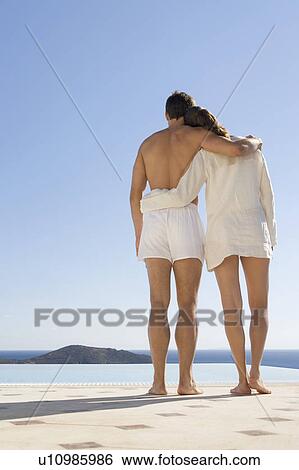 A couple relaxing by a pool View Large Photo Image Stock Photograph - A couple relaxing by a pool. Fotosearch