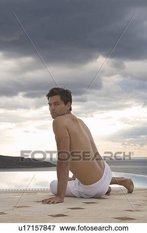 A man sitting by a pool View Large Photo Image Stock Photo - A man sitting by a pool. Fotosearch