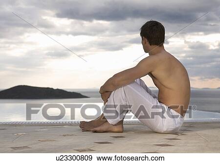 A man sitting by a pool View Large Photo Image Stock Photo - A man sitting by a pool. Fotosearch