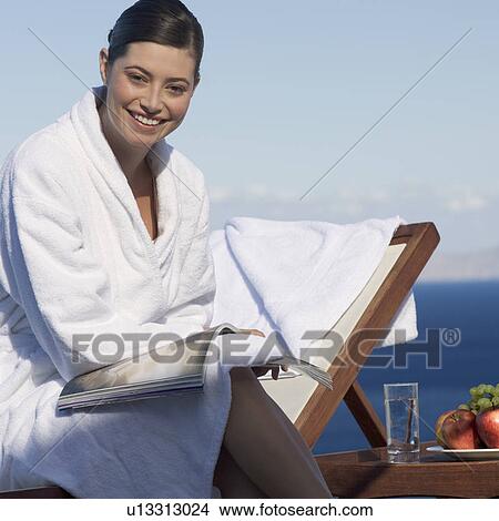 Picture - A woman relaxing by a pool. Fotosearch