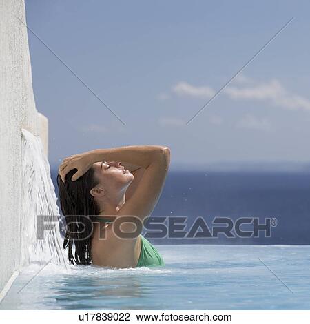 Stock Image - A woman relaxing in a pool. Fotosearch