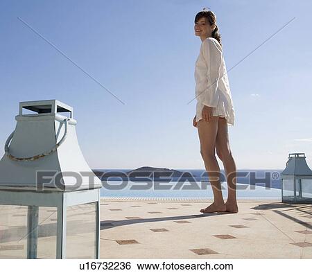Stock Photograph - A woman standing by a pool. Fotosearch