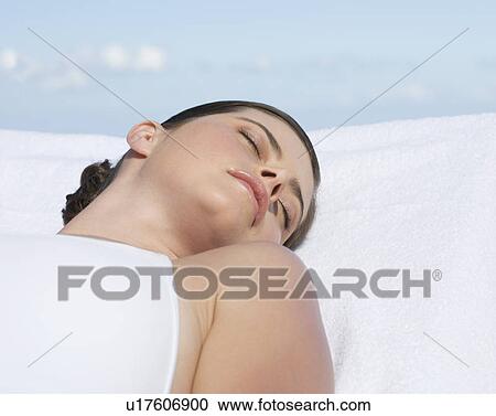 A woman sunbathing by a pool View Large Photo Image Stock Image - A woman sunbathing by a pool. Fotosearch