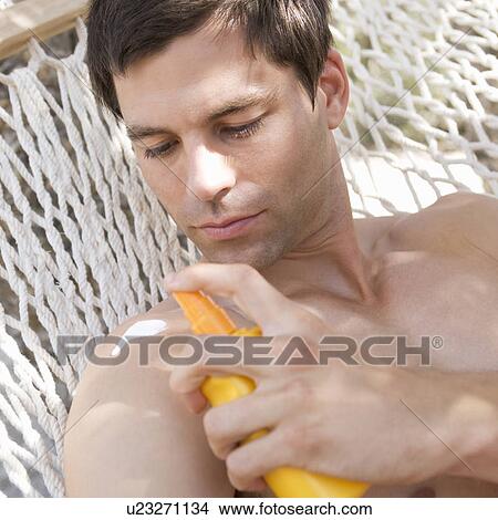 A man applying sun lotion View Large Photo Image Picture - A man applying sun lotion. Fotosearch