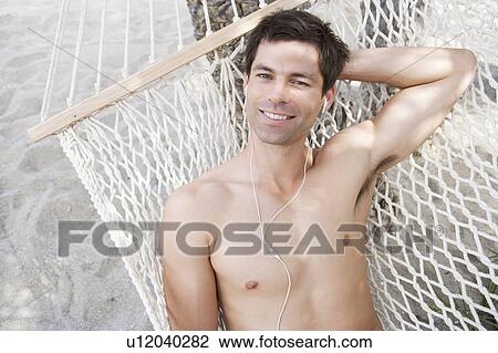 Stock Image - A man relaxing in a hammock. Fotosearch