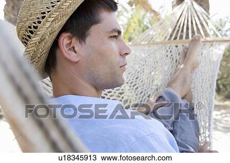 A man relaxing in a hammock View Large Photo Image Stock Image - A man relaxing in a hammock. Fotosearch