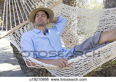 Stock Photograph - A man relaxing in a hammock. Fotosearch