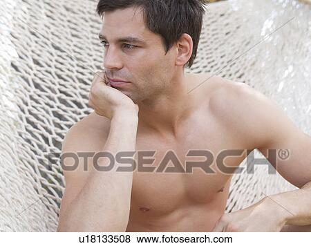 A man sitting in a hammock View Large Photo Image Stock Photo - A man sitting in a hammock. Fotosearch