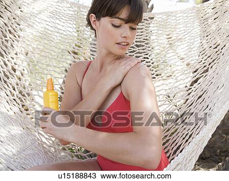 Stock Image - A woman applying sun lotion. Fotosearch
