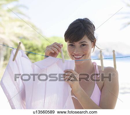 A woman hanging washing out to dry View Large Photo Image Stock Photo - A woman hanging washing out to dry. Fotosearch
