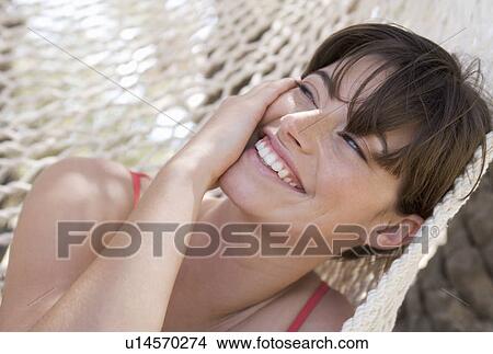 A woman relaxing in a hammock View Large Photo Image Picture - A woman relaxing in a hammock. Fotosearch