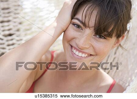 Stock Photography - A woman relaxing in a hammock. Fotosearch