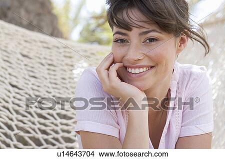 A woman sitting in a hammock View Large Photo Image Picture - A woman sitting in a hammock. Fotosearch