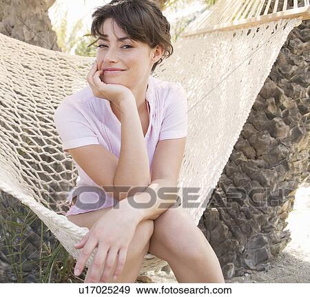 A woman sitting in a hammock View Large Photo Image Stock Photo - A woman sitting in a hammock. Fotosearch