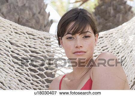A woman sitting in a hammock View Large Photo Image Stock Photo - A woman sitting in a hammock. Fotosearch