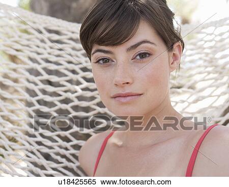 Stock Photography - A woman sitting in a hammock. Fotosearch