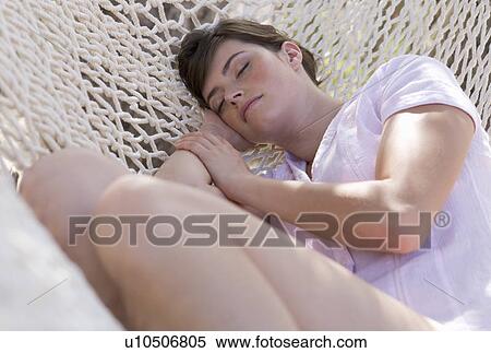 Stock Photography - A woman sleeping in a hammock. Fotosearch