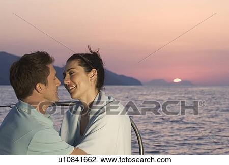 Stock Image - A couple kissing on a boat. Fotosearch