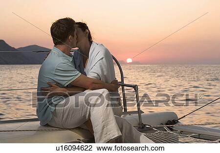 Stock Image - A couple kissing on a boat. Fotosearch