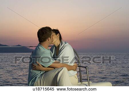 Stock Photography - A couple kissing on a boat. Fotosearch