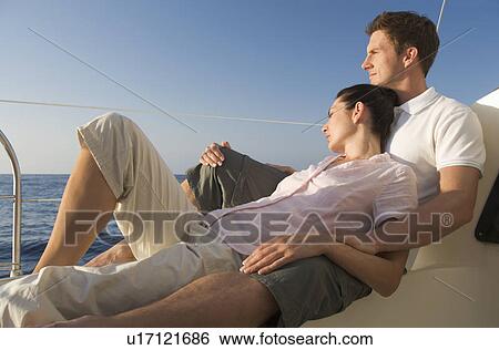 Stock Photograph - A couple relaxing on a boat. Fotosearch