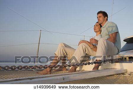 A couple relaxing with a drink on a boat View Large Photo Image Stock Photo - A couple relaxing with a drink on a boat. Fotosearch