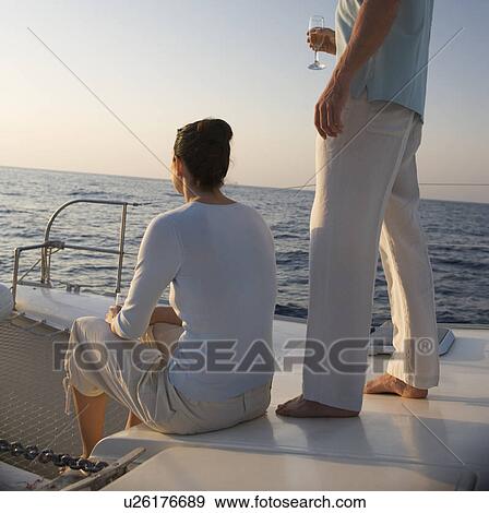 A couple relaxing with a drink on a boat View Large Photo Image Stock Photo - A couple relaxing with a drink on a boat. Fotosearch