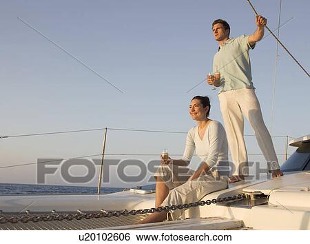 A couple relaxing with a drink on a boat View Large Photo Image Stock Photograph - A couple relaxing with a drink on a boat. Fotosearch