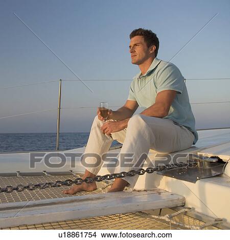 A man relaxing with a drink on a boat View Large Photo Image Picture - A man relaxing with a drink on a boat. Fotosearch