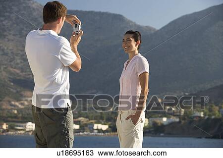 A man taking a photo of his partner on holiday View Large Photo Image Stock Image - A man taking a photo of his partner on holiday. Fotosearch